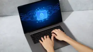 Neuer Secure-Boot-Ordner in Windows 11 – Was steckt dahinter? 5 Geöffnetes Notebook mit blauem Bildschirm; darauf ist ein Ordner-Symbol mit einem Schloss dargestellt, das für geschützte oder gesicherte Dateien steht.