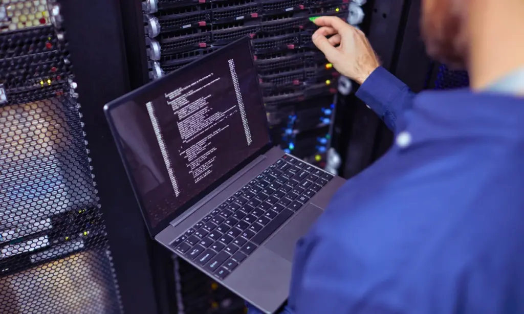 IT-Experte mit einem Notebook an einem Server