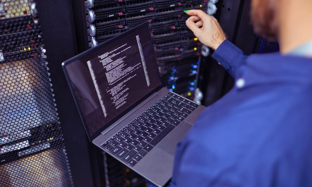 IT-Experte mit einem Notebook an einem Server
